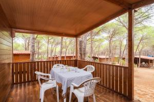 una mesa y sillas en un porche cubierto en Villaggio Camping Calapineta, en Siniscola