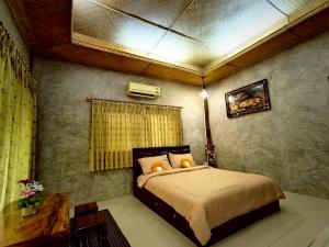 a bedroom with a bed in a room at Phakphing Erawan Homestay - พักพิง เอราวัณ โฮมสเตย์ in Tha Kradan