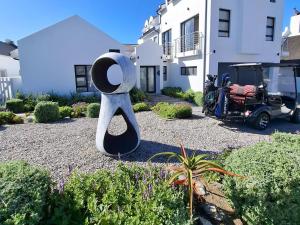 a sculpture of a hat in a garden with a wheelchair at 6 on Third in Stompneusbaai +10 photos