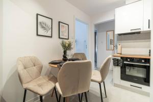 a kitchen and dining room with a table and chairs at Apartly - City Home &A in Szczecin +8 photos