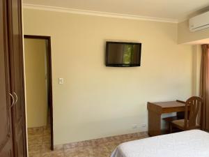 ein Schlafzimmer mit einem Bett und einem TV an der Wand in der Unterkunft Habitación Cómoda y Confortable, Zona Norte, Santa Cruz in Santa Cruz de la Sierra