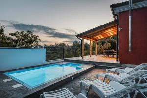 a swimming pool with chairs next to a house at Casa Lutoma in Kmeti