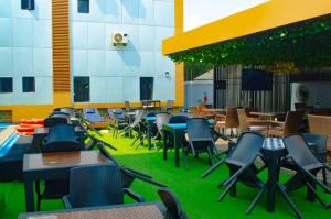 a restaurant with chairs and tables and a green lawn at Bremmy Multilinks Hotels and Suites in Asaba
