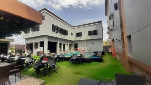 a building with a yard with chairs and a swimming pool at Bremmy Multilinks Hotels and Suites in Asaba