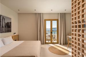 a bedroom with a bed and a view of the ocean at Portiani Suites in Adamantas