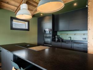 eine Küche mit schwarzen Schränken und einer schwarzen Arbeitsplatte in der Unterkunft Splendide chalet 6 pièces, jacuzzi et sauna, proche pistes à La Plagne Montalbert - FR-1-755-24 in Aime La Plagne