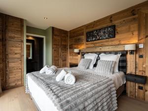 ein Schlafzimmer mit einem großen Bett mit Holzwänden in der Unterkunft Splendide chalet 6 pièces, jacuzzi et sauna, proche pistes à La Plagne Montalbert - FR-1-755-24 in Aime La Plagne
