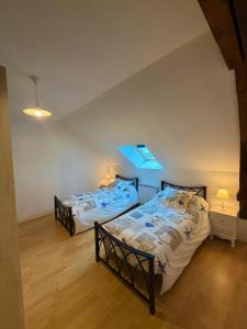 two twin beds in a room with a ceiling at Gîte la Nobleterie - Zoo de Beauval 35 min in Frédillé