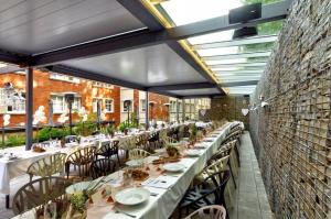 a restaurant with long tables and chairs and ceilings at Hotel Tomášov in Zlín