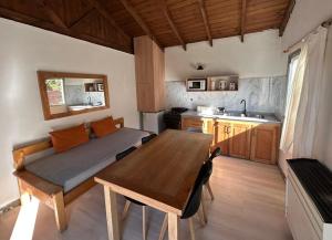 a kitchen with a table and a bed in a room at Complejo Como Vaca in El Chalten