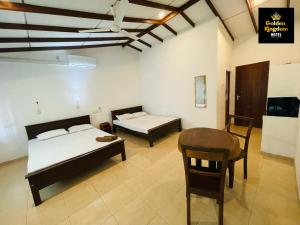 a room with two beds and a desk and a table at Golden Kingdom Hotel in Kandy +8 photos