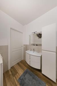 a white bathroom with a sink and a mirror at Vivere il Parco in Lonato +21 photos