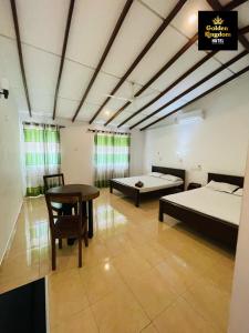 a large room with two beds and a table at Golden Kingdom Hotel in Kandy