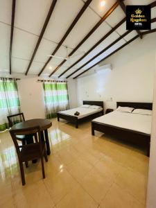 a room with two beds and a table in it at Golden Kingdom Hotel in Kandy