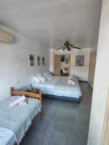 a bedroom with two beds and a ceiling fan at Natura Escapade Guesthouse in Torrox +20 photos