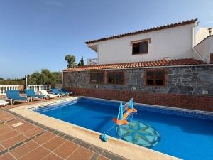 a swimming pool in front of a house at Natura Escapade Guesthouse in Torrox