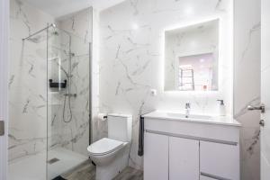 a white bathroom with a toilet and a shower at Duplex-Port-Valencia in Valencia +31 photos
