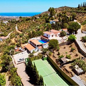 an aerial view of a house with a tennis court at Natura Escapade Guesthouse in Torrox