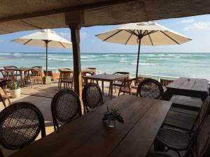 una mesa y sillas con mesas y sombrillas en la playa en Pelican Ahangama, en Ahangama