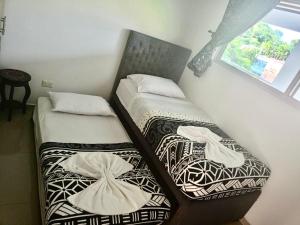 two twin beds in a room with a window at Apartamento con Piscina y Vista panoramica Anapoima Centro in Anapoima +11 photos