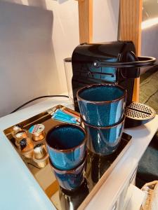 布鲁日Tiny House The Bird House的两只蓝色玻璃杯放在烤面包机旁边的托盘上。