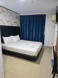 a bed in a room with a blue curtain at Hotel Seri Putra in Kuala Lumpur +16 photos