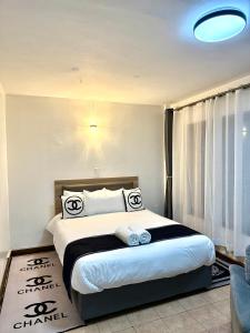 a bedroom with a large bed with black and white pillows at Emeli Hotel Luxury Suites in Nairobi