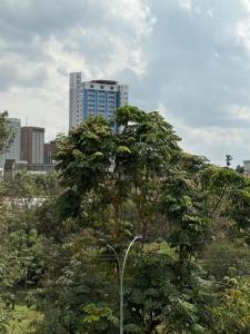 a tree in front of a tall building at Emeli Hotel Luxury Suites in Nairobi