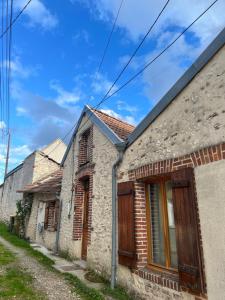 une vieille maison en pierre avec des portes en bois dans une rue dans l'établissement La maison bohème, à Romorantin-Lanthenay