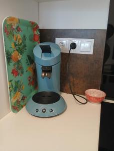 een blauw koffiezetapparaat op een aanrecht naast een doos bij Petite Maison dans le Gers 32 in Mouchan