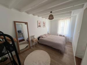 une petite chambre avec un lit et un miroir dans l'établissement La maison bohème, à Romorantin-Lanthenay