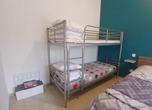 een slaapkamer met 2 stapelbedden en een bed bij Petite Maison dans le Gers 32 in Mouchan