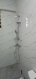 een douche in een badkamer met een witte bakstenen muur bij Beatrix Valley, 1 Bedroom Modern Luxury in Tema