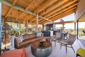 ein offenes Wohnzimmer mit einem Sofa und einem Tisch in der Unterkunft Dune Seaside Cottage in Plettenberg Bay