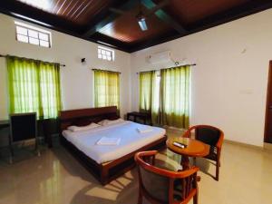 ein Schlafzimmer mit einem Bett und einem Tisch und Stühlen in der Unterkunft Boho Heritage in Kochi in Kochi