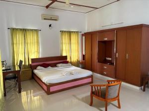 une chambre avec un lit, un bureau et une table dans l'établissement Boho Heritage in Kochi, à Cochin