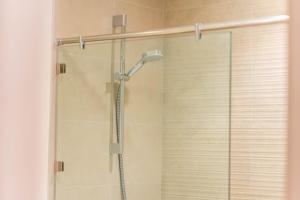 eine Dusche mit Glastür im Badezimmer in der Unterkunft Yas Golf Collection 1 BR Near Theme Parks in Abu Dhabi + 32 Fotos