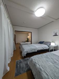 two beds in a room with white walls at ann近島 in Gifu