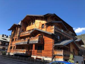 a large wooden building with balconies on a street at Appartement moderne au pied des pistes avec parking, wifi à Morzine - FR-1-754-87 in Morzine +5 photos