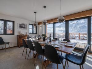 ein Esszimmer mit Tisch und Stühlen und Fenstern in der Unterkunft Chalet moderne, 5 chambres, proche remontées, parking, Wi-Fi - FR-1-754-88 in Morzine
