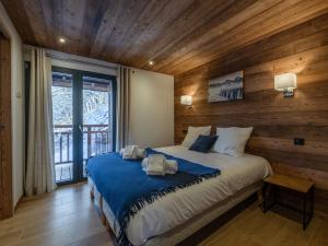 ein Schlafzimmer mit einem Bett mit einer Holzwand in der Unterkunft Chalet moderne, 5 chambres, proche remontées, parking, Wi-Fi - FR-1-754-88 in Morzine