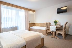 een hotelkamer met een bed, een bureau en een tafel bij Penzión u Pavla in Ždiar +42 foto's