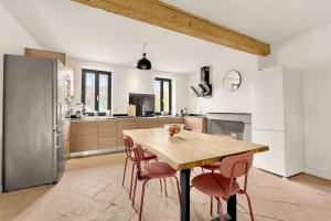 une cuisine avec une table en bois et des chaises roses dans l'établissement Villa haut de gamme avec piscine, à Gagnac-sur-Garonne