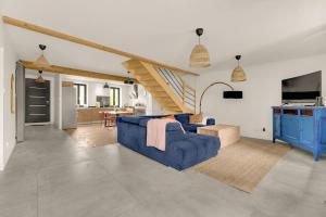 un salon avec un canapé bleu et un escalier dans l'établissement Villa haut de gamme avec piscine, à Gagnac-sur-Garonne