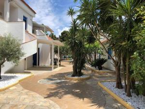 une cour avec des palmiers à côté d'un bâtiment dans l'établissement Regent Beachotel, à Reggio de Calabre