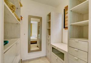 a bedroom with white closets and a mirror at Villa Swahili1 in Les Avirons