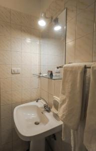 Un baño con un lavabo blanco y un espejo. en Cleopatra Hotel, en Asuán