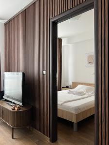 コパオニクにあるApartman Iva Kraljevi Čardaciのベッドルーム(ベッド1台、テーブル上のテレビ付)