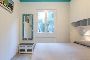 a bedroom with a large bed and a window at Appartamento Pino Fetovaia by ElbaSummer Tour Operator in Fetovaia +10 photos