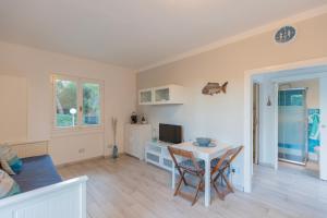 a living room with a white table and chairs at Appartamento Pino Fetovaia by ElbaSummer Tour Operator in Fetovaia